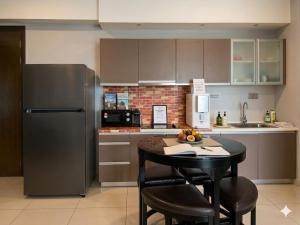 a kitchen with a table and a refrigerator at Ehsan Suites in Kuala Lumpur