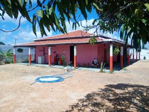 a small pink house with a blue hose in the yard at Hostel Mamitchesca in Canoa Quebrada +19 photos