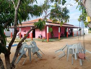 a group of chairs in front of a house at Hostel Mamitchesca in Canoa Quebrada