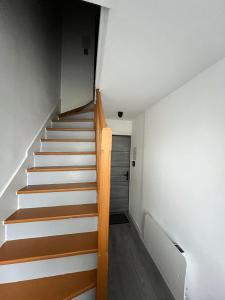 a staircase in a house with white walls and wooden floors at horizon doux in Calais +1 photo