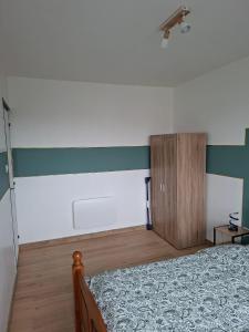 a bedroom with a bed and a wooden cabinet at horizon doux in Calais