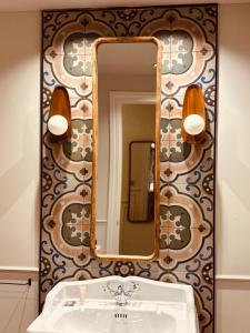 a bathroom with a mirror and a sink at Hotel Villa Ruy López in Zafra +165 photos
