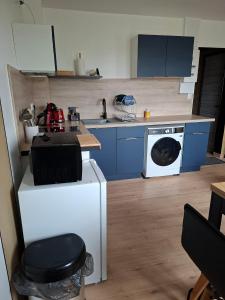 a kitchen with blue cabinets and a washing machine at horizon doux in Calais
