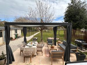 a patio with a gazebo and a table and chairs at Le Cocon de Vlinette in Brienne-le-Château