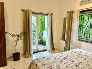 a bedroom with a bed and a window and a plant at Marshmallow - by MA Homes in Morjim