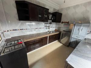 a kitchen with wooden cabinets and stainless steel appliances at Apparemment à louer in Derroua