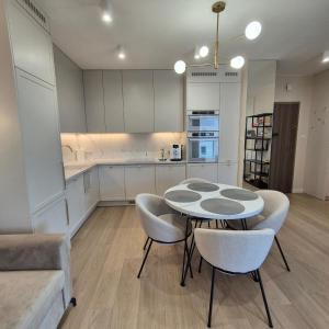 a kitchen with a table and chairs in a room at Apartment Comfort Premium in Bartoszyce