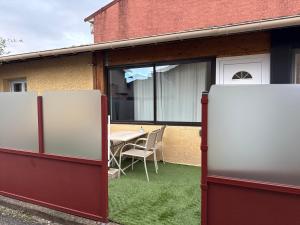 two refrigerators in front of a house with a table at Appartement le cocon de terre in Ambérieu-en-Bugey +33 photos
