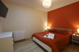 a bedroom with a red bed with two towels on it at Appartement le cocon de terre in Ambérieu-en-Bugey