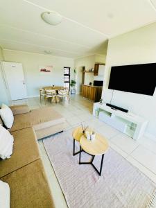 a living room with a large flat screen tv at Spacious 3 Bedroom Apartment in Ballito Hills Lifestyle Estate Near Ballito Beach in Ballito