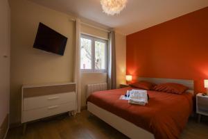 a bedroom with orange walls and a bed and a window at Appartement le cocon de terre in Ambérieu-en-Bugey
