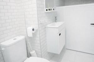 a white bathroom with a toilet and a sink at Tangier city center 1 in Tangier