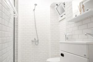 a white bathroom with a shower and a toilet at Tangier city center 1 in Tangier