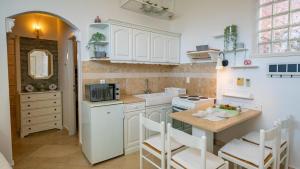 a kitchen with white cabinets and a sink and a counter at Apartments Barbara in Lovran
