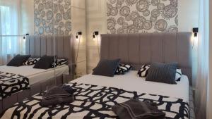 a bedroom with two beds with black and white pillows at Apartments Barbara in Lovran +92 photos