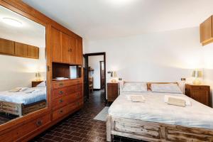 a bedroom with two beds and a dresser at Chalet Niki BELLAGIO in Bellagio