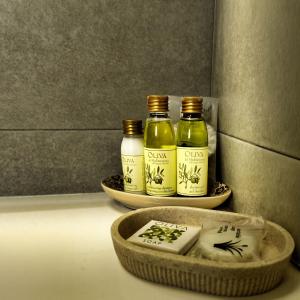 three bottles of olive oil and a bowl of soap at Finca Tres Molinos B&B in Roldán