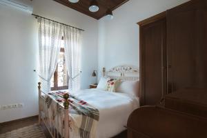 a white bedroom with a bed and a window at Αρχοντικό Ταξίμι - Ανθέων Έμπνευση in Argalasti +169 photos