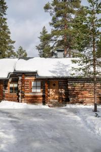 a log cabin with snow on the roof at Pikkukelo Ruka in Ruka
