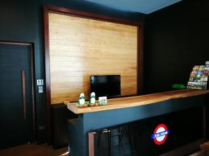 a bar in a room with a wooden wall at Ashi Hostel in Chiang Mai