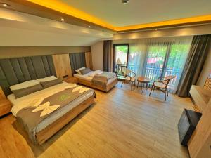 a hotel room with two beds and a couch at Akyuz Kardesler Hotel & Bungalow in Uzungöl