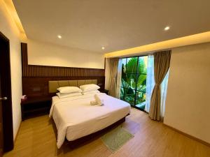 a bedroom with a bed and a large window at Seaside Drift in Huraa