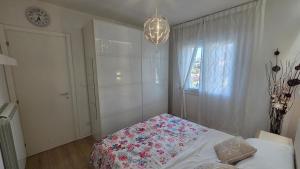 a bedroom with a bed and a window and a chandelier at Loft@Lounge in Grado-Pineta +13 photos