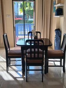 a dining room table with two chairs and a glass table at Cozy Suite, Wifi, Ac in Bedroom & 1 Minute Walk to West Coast Beach! in Saint James +8 photos