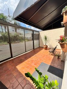 an outdoor patio with awning and plants at Hotel Norte Sul in Campo Grande