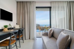 a living room with a couch and a view of the ocean at Videre Golden Private Pool Suites in Potamiá