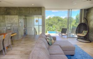 a large living room with a couch and a dining room at Villa Los Laureles III, Private Pool, Nature Trails, Beaches in Esterillos Este