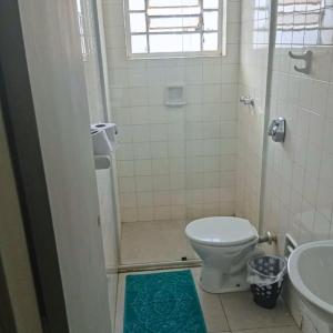 a small bathroom with a toilet and a sink at ALVORADA PALACE HOTEL in Bauru