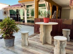 a table and two stools on a patio at Pousada Mel e Mar in Penha