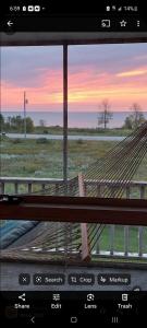 a view of a hammock with a sunset in the background at Beach House Overlooking Lake Michigan in Algoma