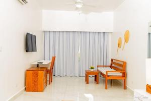 a living room with a table and chairs and a television at Stars Hotel Bavaro in Punta Cana