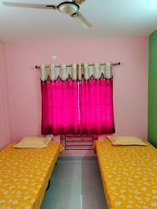 two beds in a room with a pink curtain at Starlight Guest House in kolkata