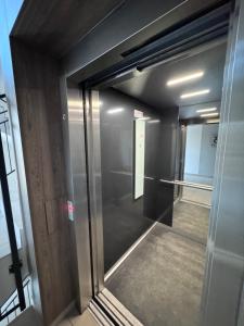 a glass door to a elevator in a building at Apartment Comfort Premium in Bartoszyce