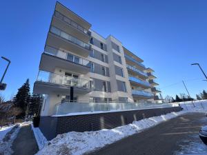 an apartment building in the snow on a street at Apartment Comfort Premium in Bartoszyce
