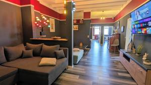 a living room with a couch and a tv at RhinQuartier FeWo Loft-Style in Rheinsberg