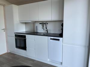 a white kitchen with a sink and a stove at DCU-Camping Kulhuse in Kulhuse
