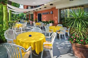 a yellow table and chairs in front of a restaurant at Hotel HARRY'S Hospitality Riccione-Fronte Mare in Riccione