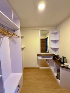a kitchen with white shelves and a wooden floor at Seaside Drift in Huraa