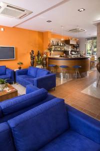 a living room with blue couches and a bar at Hotel HARRY'S Hospitality Riccione-Fronte Mare in Riccione