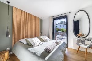 a bedroom with a bed and a mirror and a chair at Small house with swimming pool and jacuzzi in Biarritz