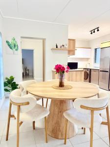 a dining room with a wooden table and chairs at Spacious 3 Bedroom Apartment in Ballito Hills Lifestyle Estate Near Ballito Beach in Ballito