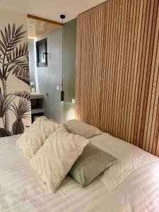 a bedroom with a bed with a wooden wall at Small house with swimming pool and jacuzzi in Biarritz +16 photos