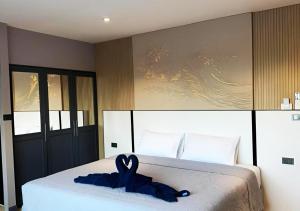 a bedroom with a bed with a blue ribbon on it at Puttaya Glow in Pattaya