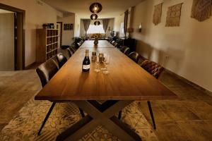 a long wooden table in a room with chairs and wine glasses at Finca Tres Molinos B&B in Roldán +44 photos