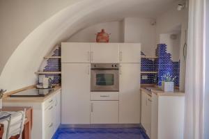 a kitchen with white cabinets and a stove top oven at Bilocale affacciato sul budello a 30 mt dal mare in Laigueglia