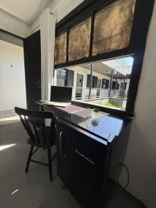 a kitchen with a desk and a chair and a window at Hostel El viajero in Tramandaí